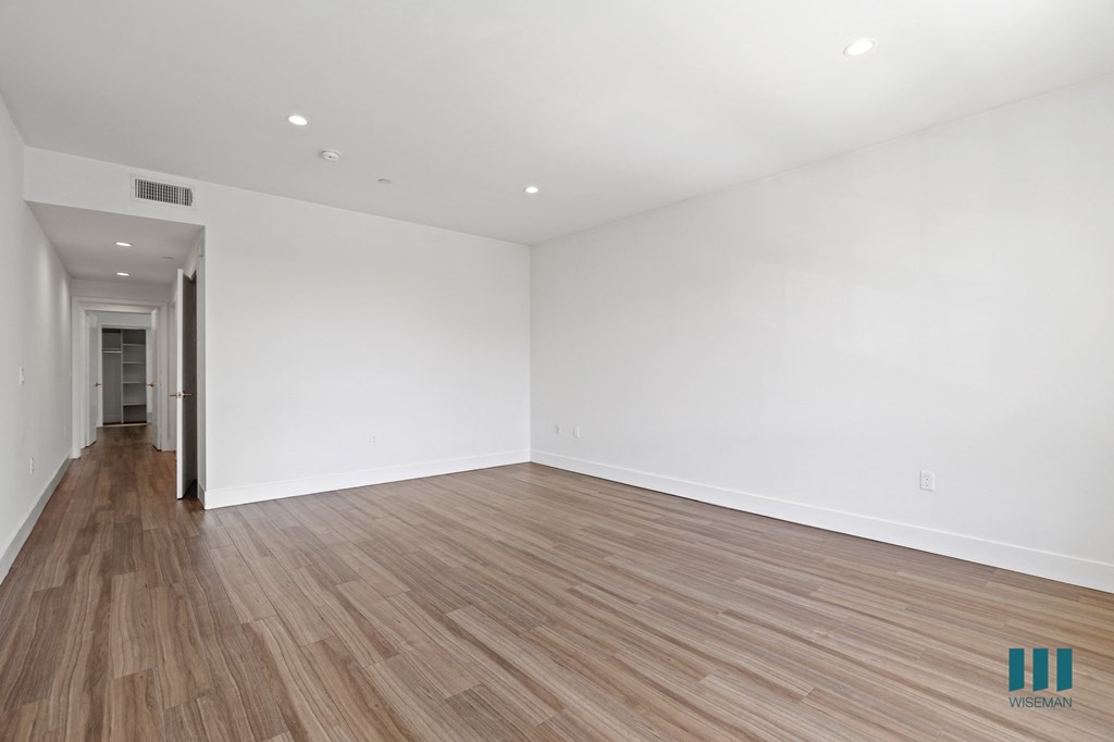 Large-Size Bedroom with Walk-In Closet with Built-In Shelving, Recessed Lighting, and Vinyl Flooring