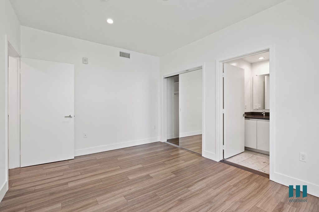 Bedroom with Bathroom, Mirrored Closet, Recessed Lighting, and Vinyl Flooring