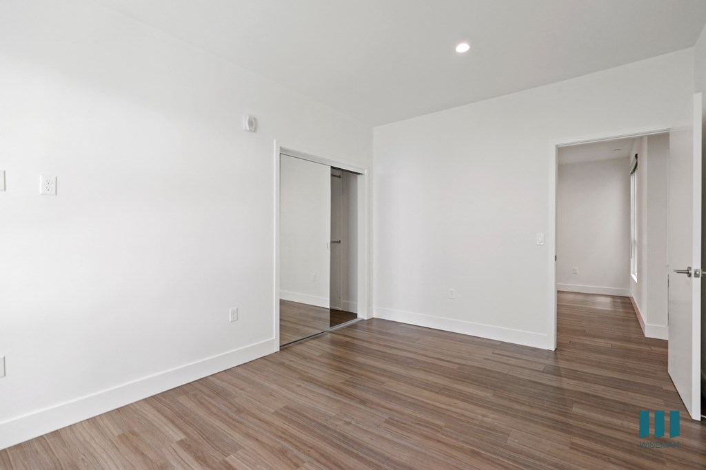 Bedroom with Mirrored Closet, Vinyl Flooring, and Recessed Lighting