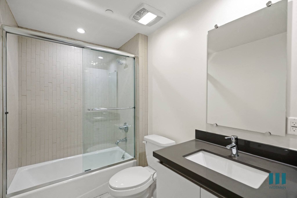 Bathroom With Full-Size Bathtub and Glass Door