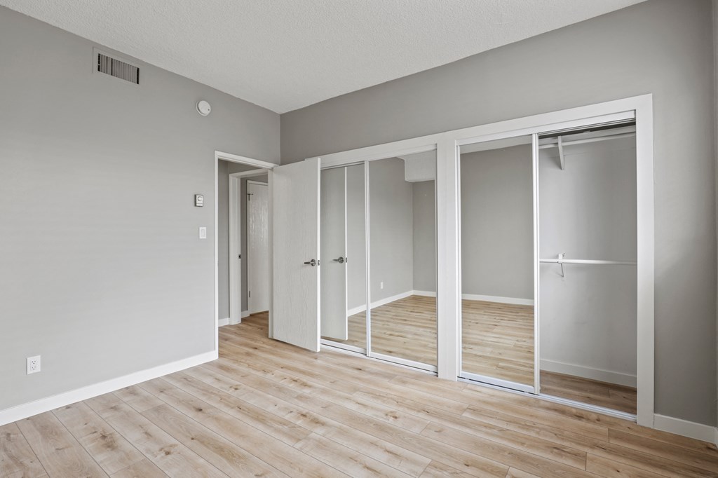 Bedroom with Mirrored Closets and Vinyl Flooring