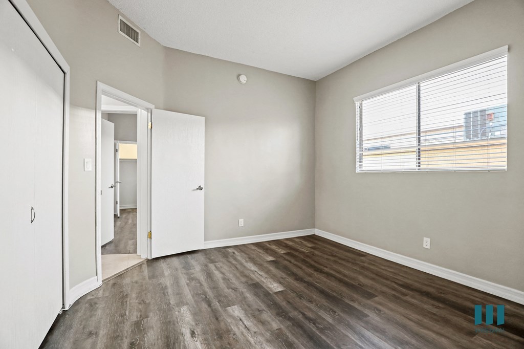Bedroom with Large Windows, Closet, and Vinyl Flooring