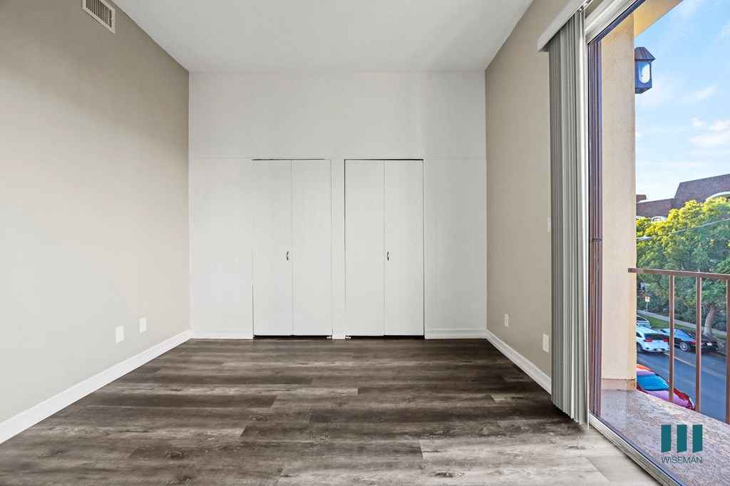 Bedroom with Double-Closets, Vinyl Flooring, and Balcony