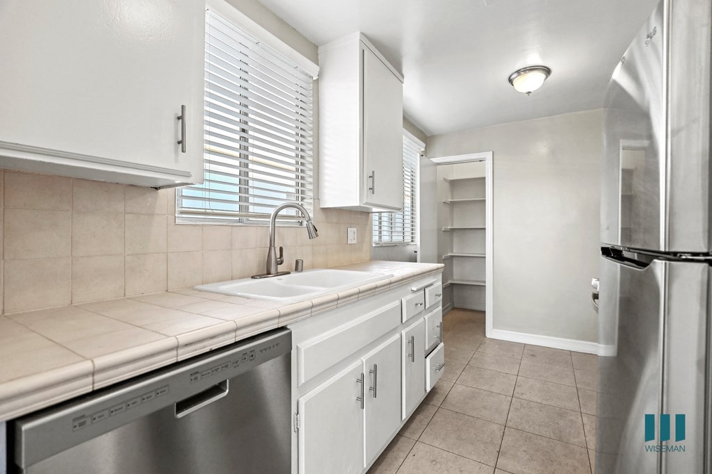 Kitchen with Stainless-Steel Dishwasher, Refrigerator, and Pantry