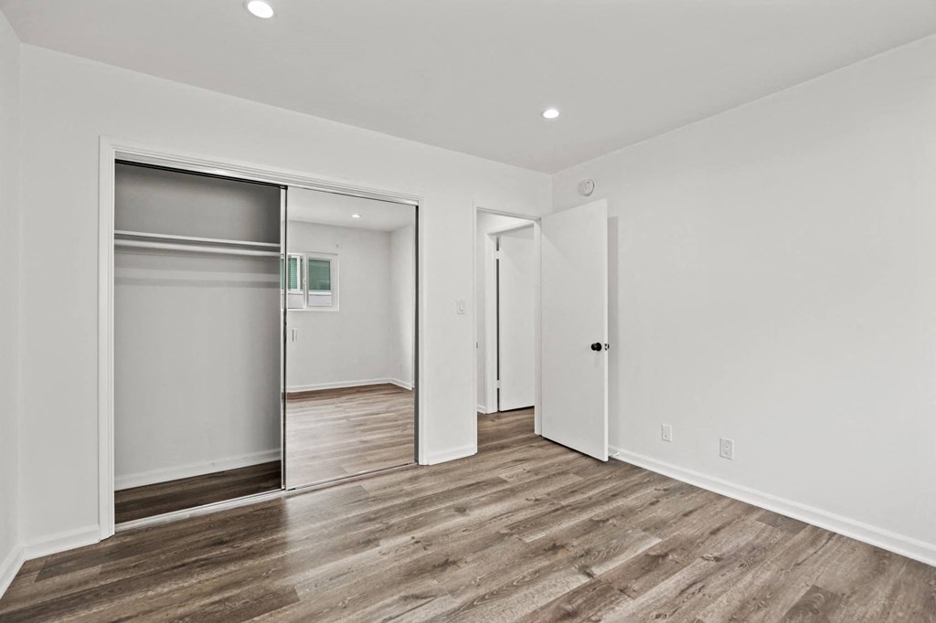 Bedroom with Mirrored Closet, Vinyl Flooring, and Recessed Lighting