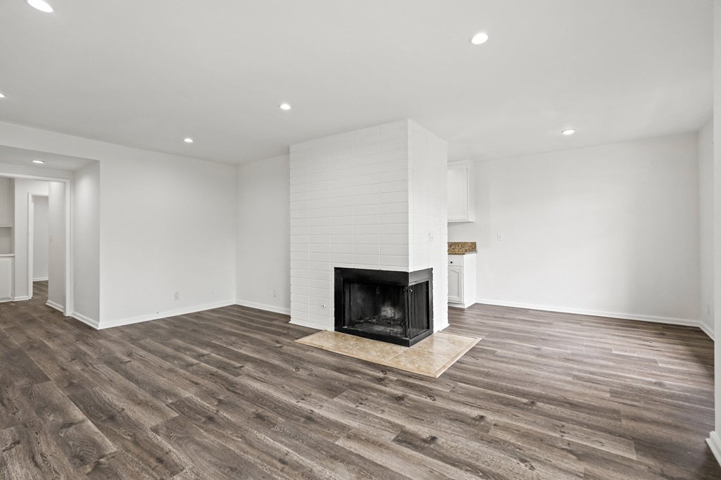 Open-Concept Dining and Living Room Space with an Electric Fireplace, Vinyl Flooring, and Recessed Lighting