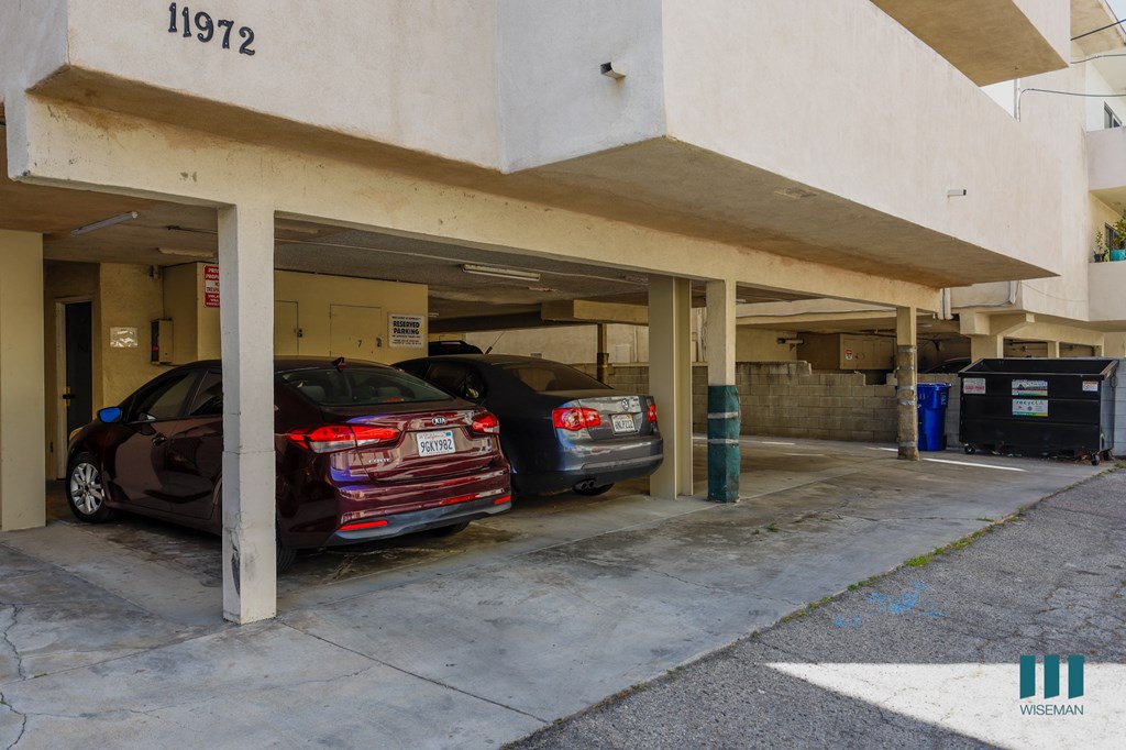 a parking garage with two cars in front of a building