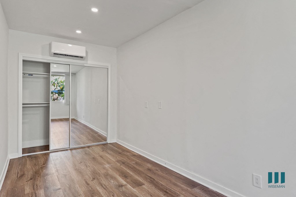 Bedroom with Mirrored Closet, Vinyl Flooring, and Recessed Lighting
