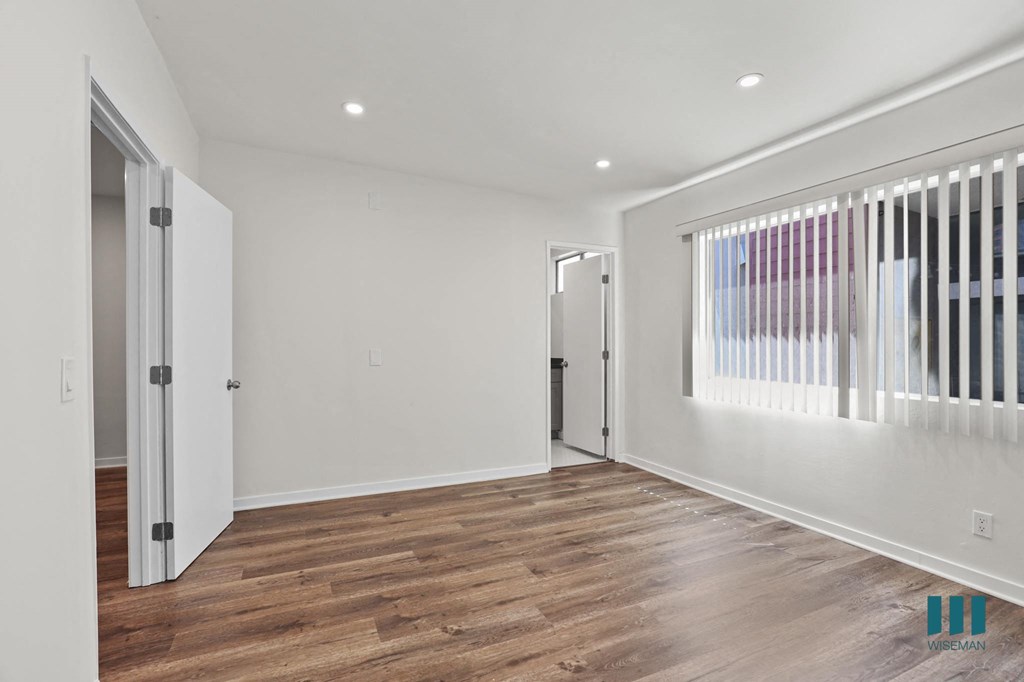 Spacious Bedroom with Large Windows, Bathroom, and Vinyl Flooring