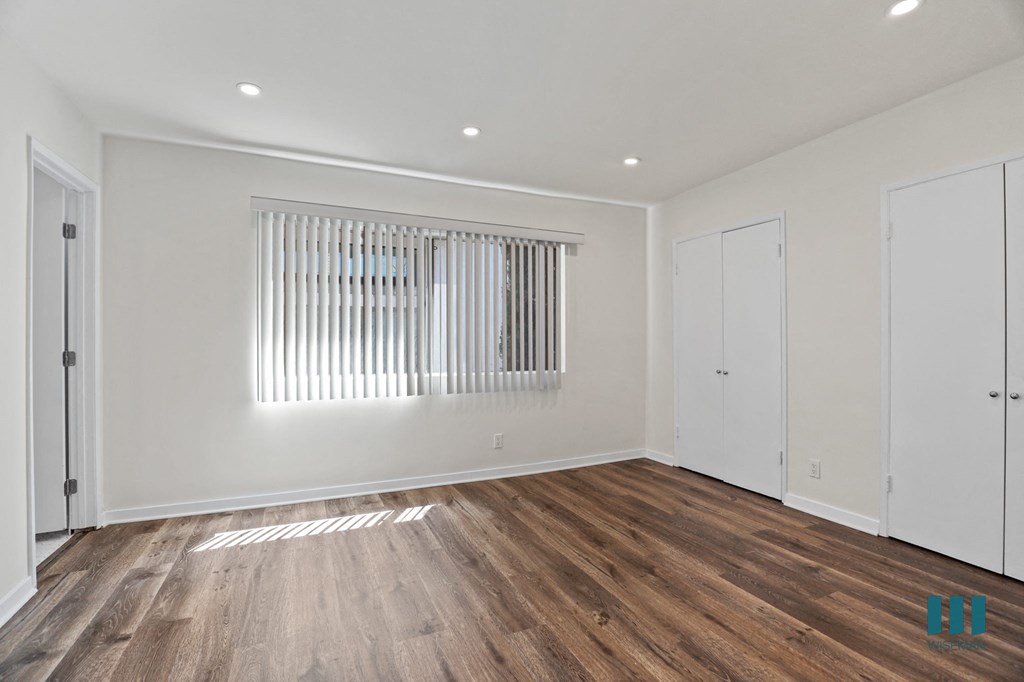 Bedroom with Large-Size Windows, Vinyl Flooring, and Closets