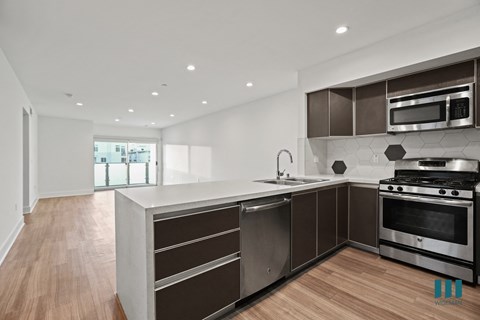 a modern kitchen with stainless steel appliances and a large counter top