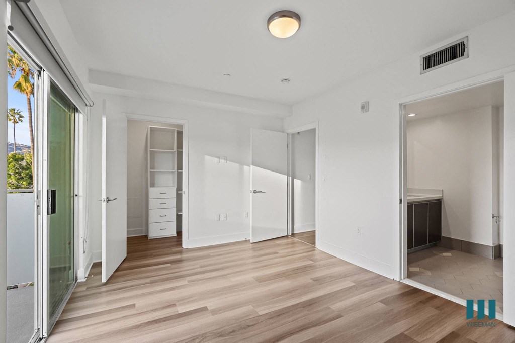Bedroom with Walk-In Closet with Built-In Organizers, Bathroom, and Patio