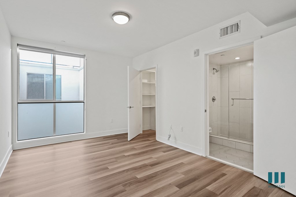 Bedroom with Bathroom, Walk-In Closet, Balcony, and Vinyl Flooring
