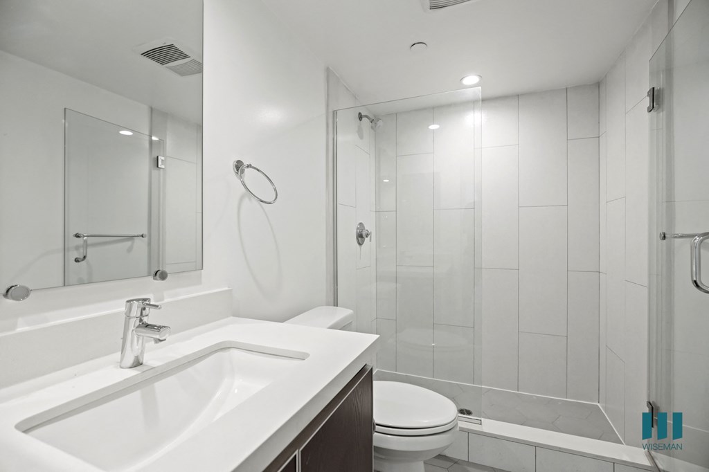 Bathroom with Walk-In Shower with Glass Door and Vanity Cabinet Storage
