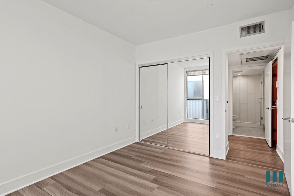 Bedroom with Mirrored Closet and Vinyl Flooring
