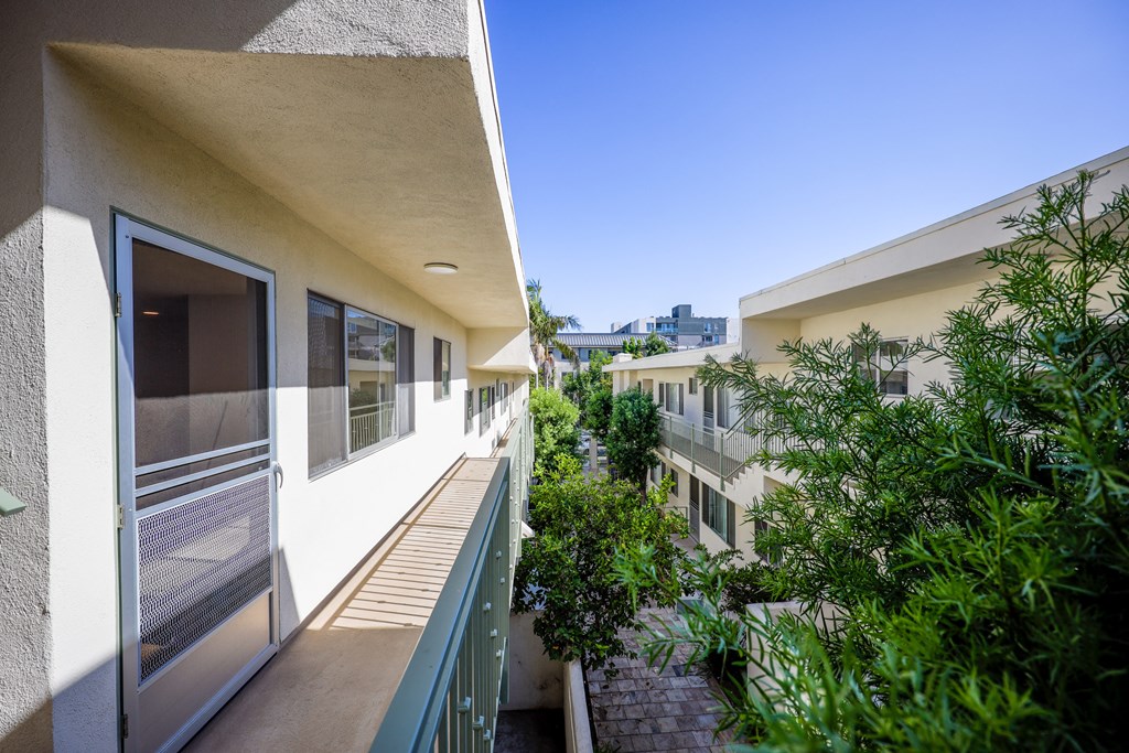 a balcony with a view of a building and some trees