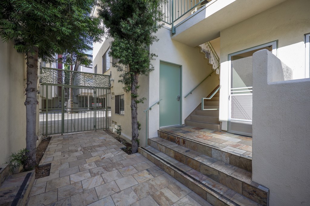 the front door of a house with stairs and a courtyard