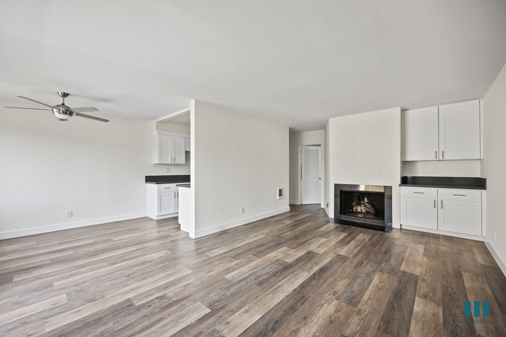 Open-Concept Dining and Living Room with Fireplace, Built-In Cabinets, and Vinyl Flooring