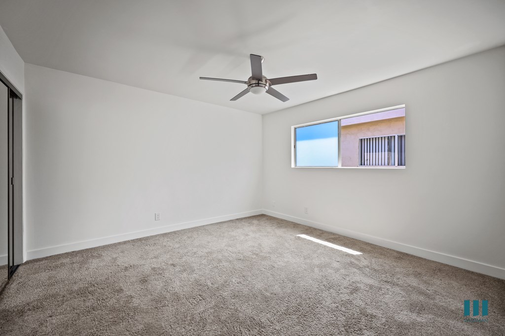 Bedroom with Mirrored Closet, Ceiling Fan, and Carpet
