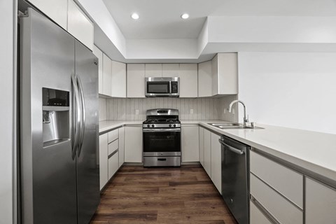 a kitchen with stainless steel appliances and white cabinets