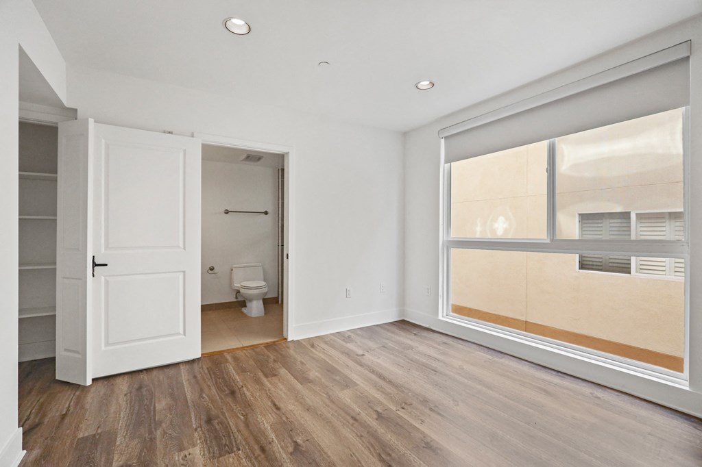 Bedroom with Bathroom, Vinyl Flooring, and Large-Size Windows