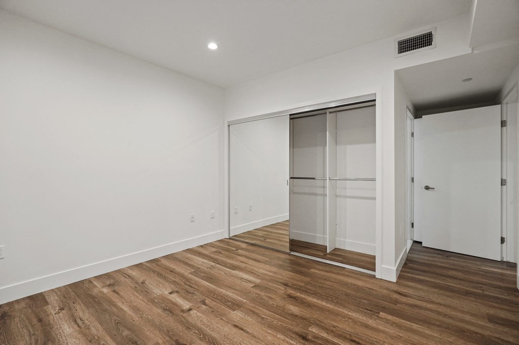 Bedroom with Mirrored Closet, Recessed Lighting, and Vinyl Flooring