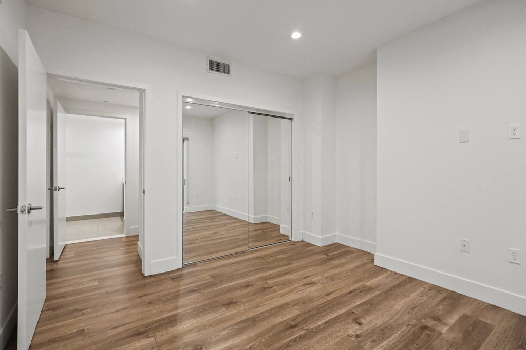 Bedroom with Mirrored Closet, Vinyl Flooring, and Recessed Lighting