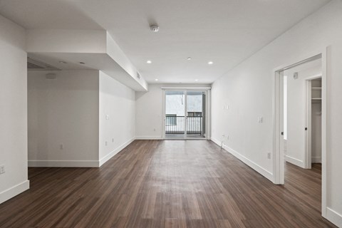 the living room of a new home with white walls and wood floors