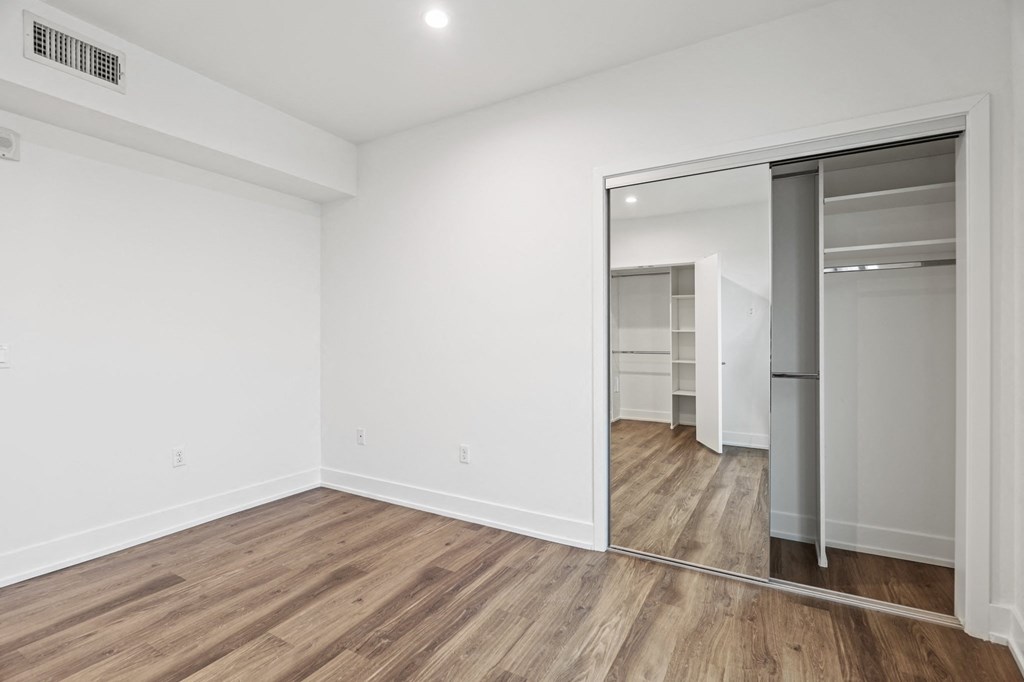 Bedroom with Mirrored Closet and Vinyl Flooring