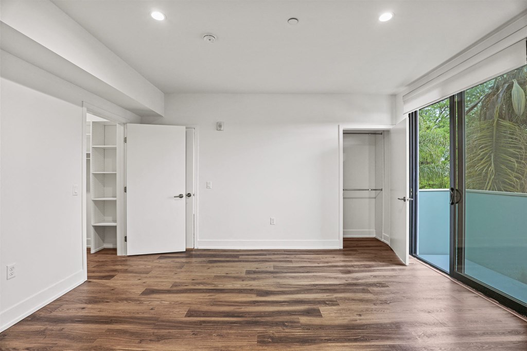 Bedroom with Two Closets, Vinyl Flooring, and Large-Size Patio