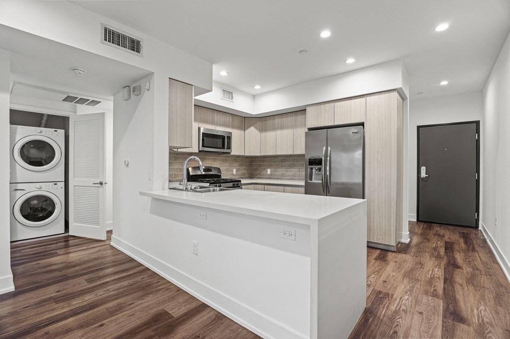 Kitchen with a Countertop Bar and In-Suite Washer & Dryer