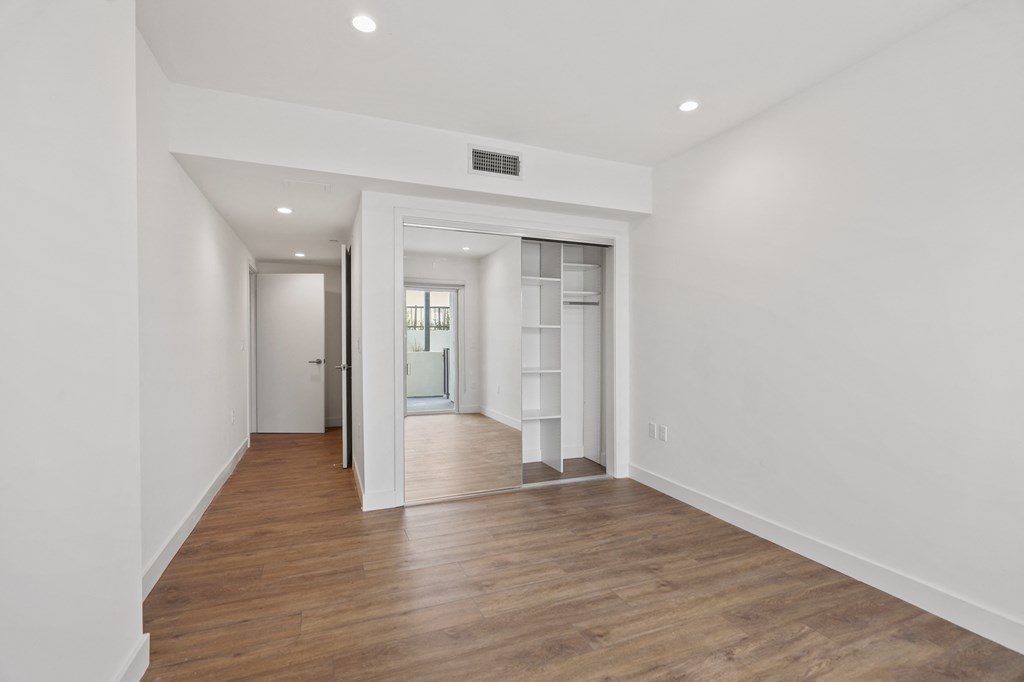 Bedroom with Mirrored Closet with Built-In Organizers, Vinyl Flooring, and Recessed Lighting