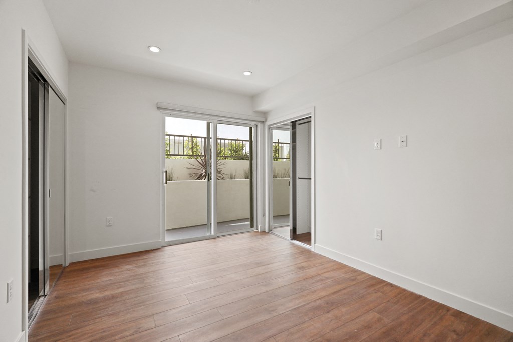 Bedroom with Two Closets, Vinyl Flooring, Recessed Lighting, and Patio