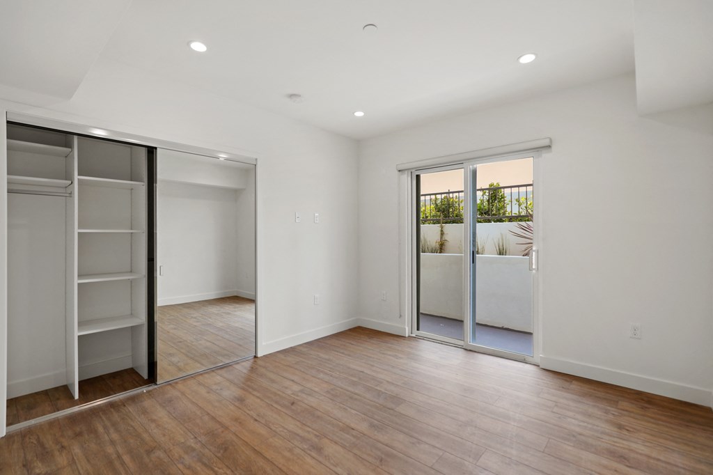 Bedroom with Mirrored Closet and Patio