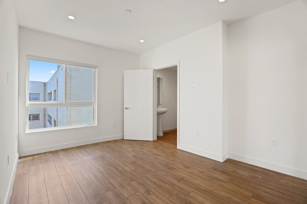 Bedroom with Large-Size Windows, Vinyl Flooring, Recessed Lighting, and Bathroom