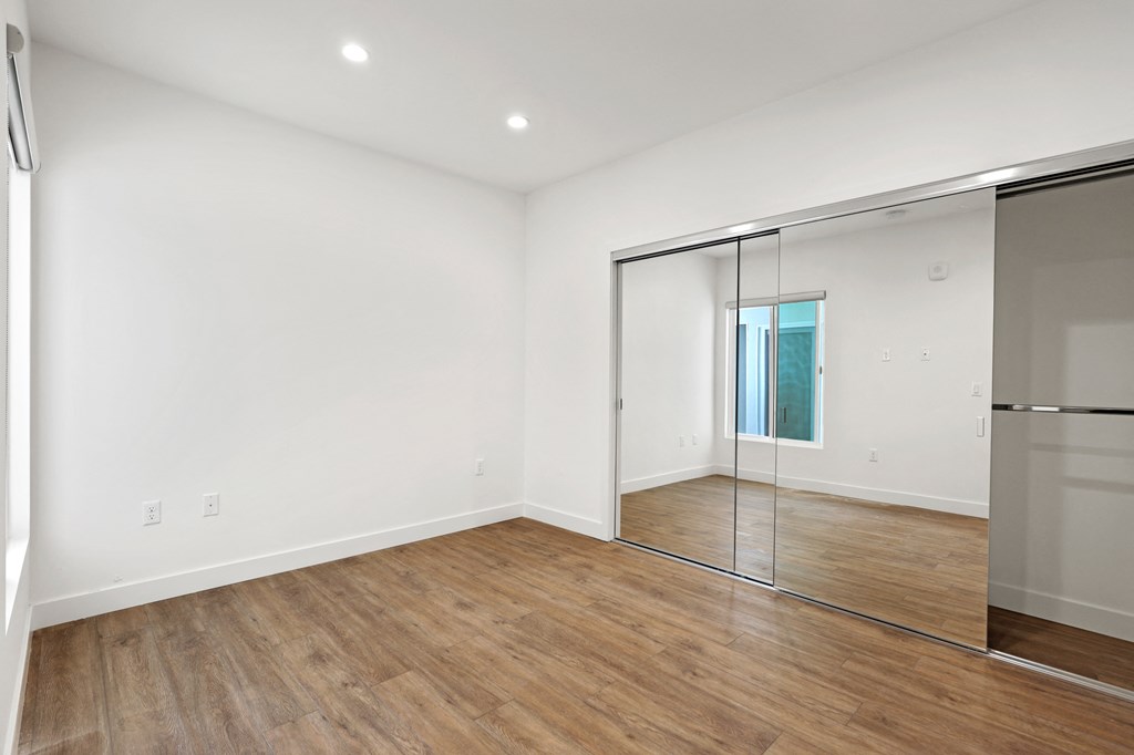 Bedroom with Large Mirrored Closet and Vinyl Flooring