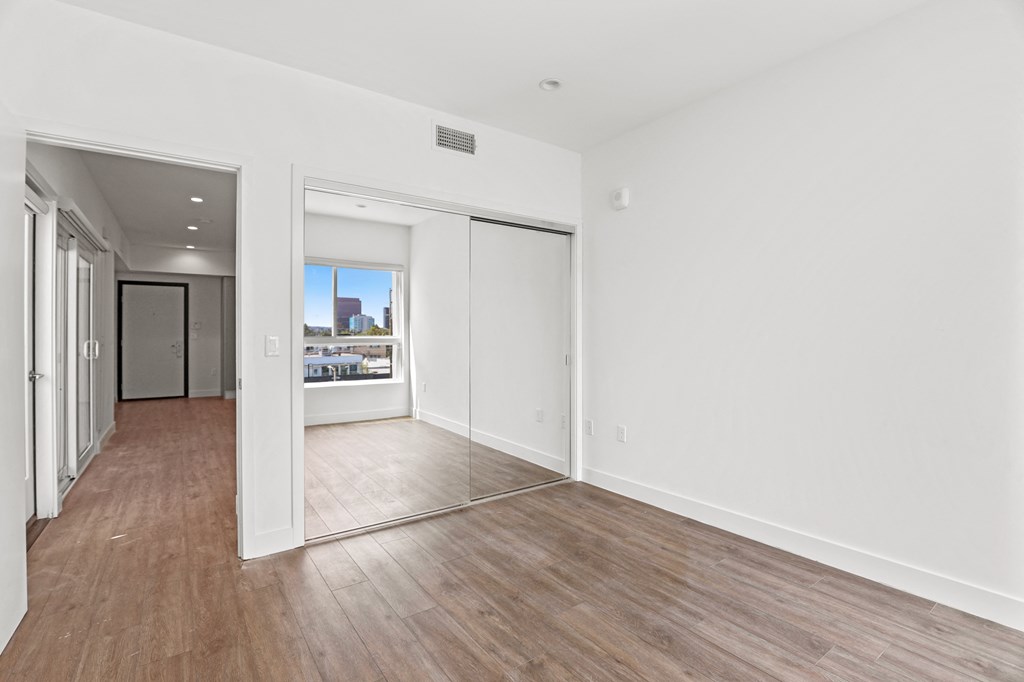 Bedroom with Mirrored Closet and Vinyl Flooring
