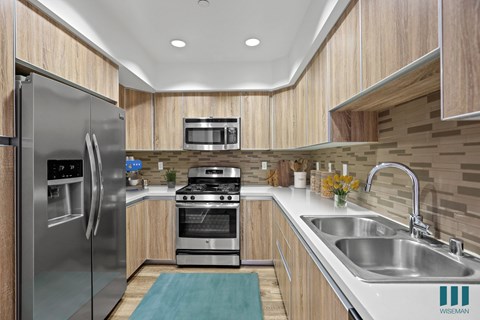 A modern kitchen with wooden cabinets and stainless steel appliances.