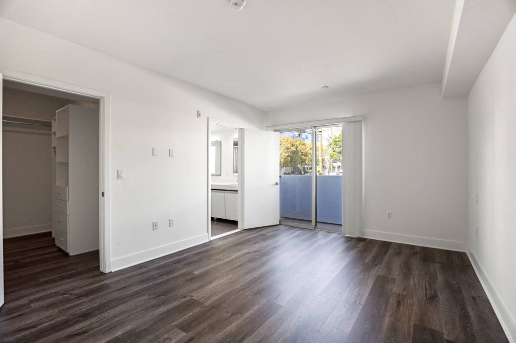 Bedroom with Walk-In Closet, Vinyl Flooring, and  Balcony