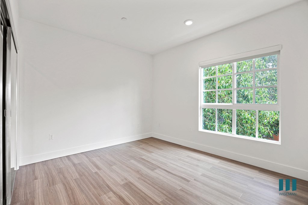 Bedroom with Large-Size Windows, Vinyl Flooring, Recessed Lighting, and Mirrored Closet
