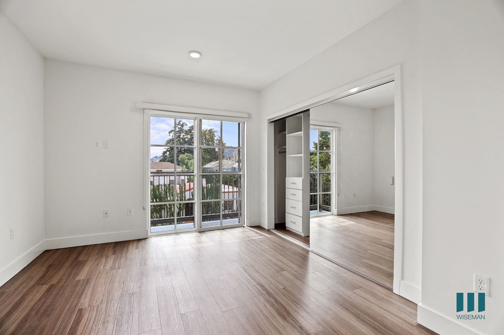 Bedroom with Mirrored Closet , Patio, and Vinyl Flooring