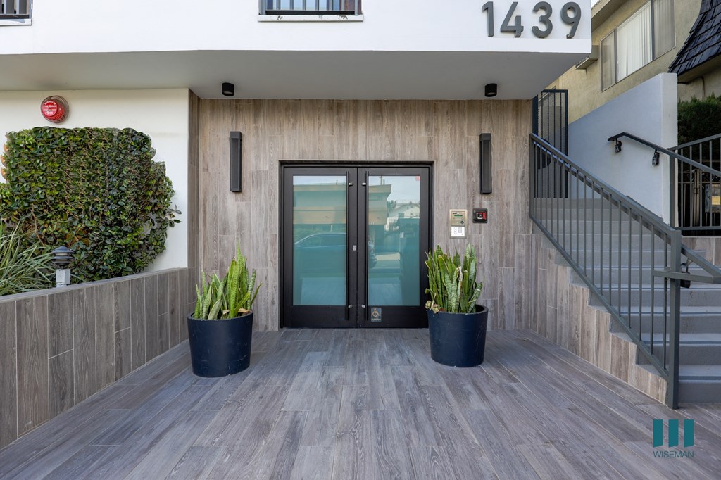 an entrance to a building with a glass door and potted plants