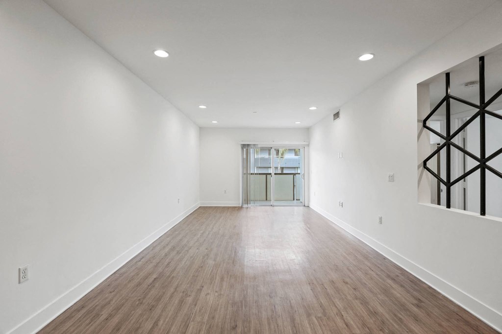 a bedroom with a medium sized bed and a doorway into a room