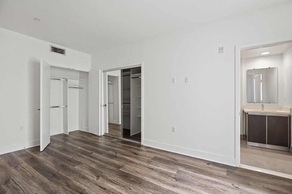 a bedroom with hardwood floors and white walls