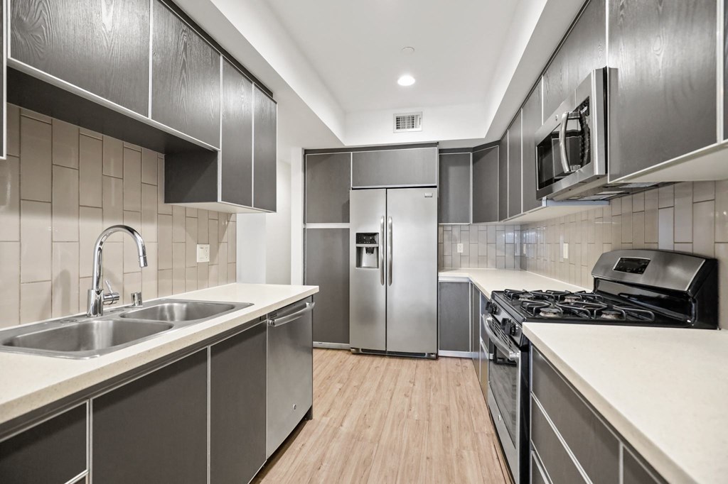 a kitchen with white countertops and stainless steel appliances