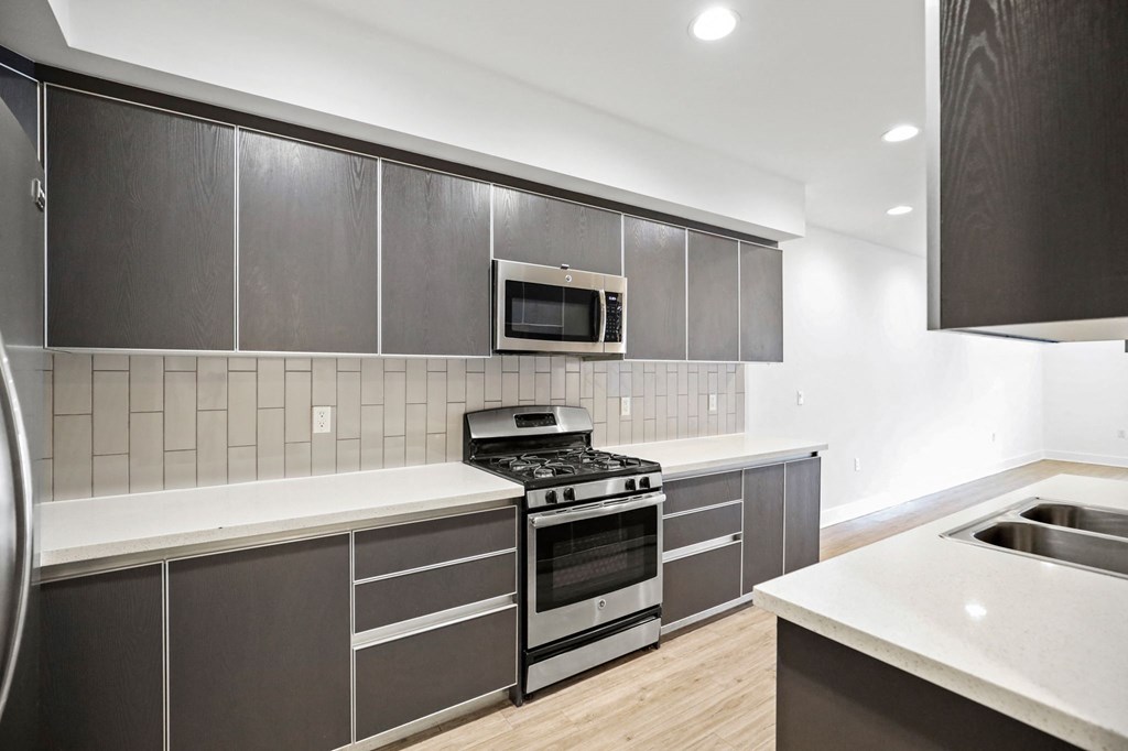 a kitchen with grey cabinets and white countertops