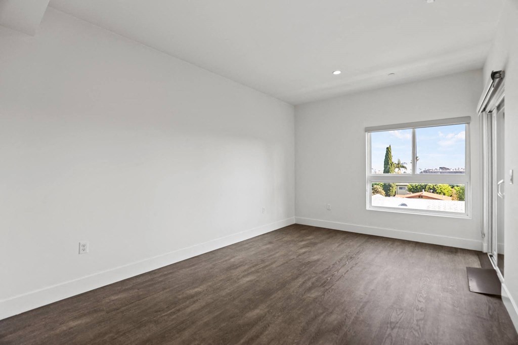 Spacious Living Room Area with Recessed Lighting, Vinyl Flooring, and Patio