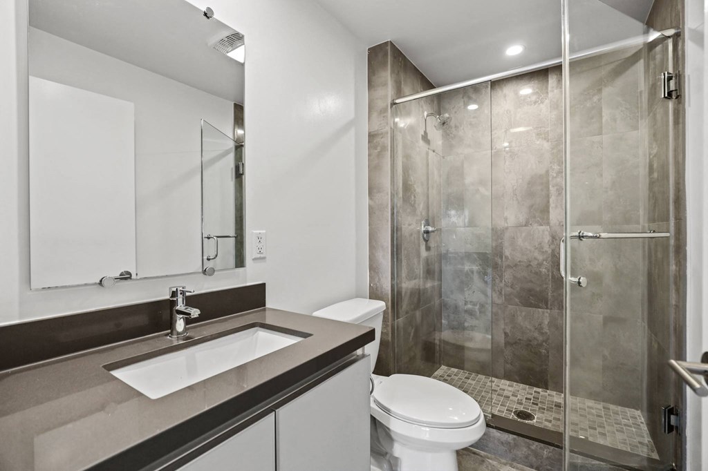 Bathroom with a Walk-In Shower with a Glass Door and Cabinet Storage