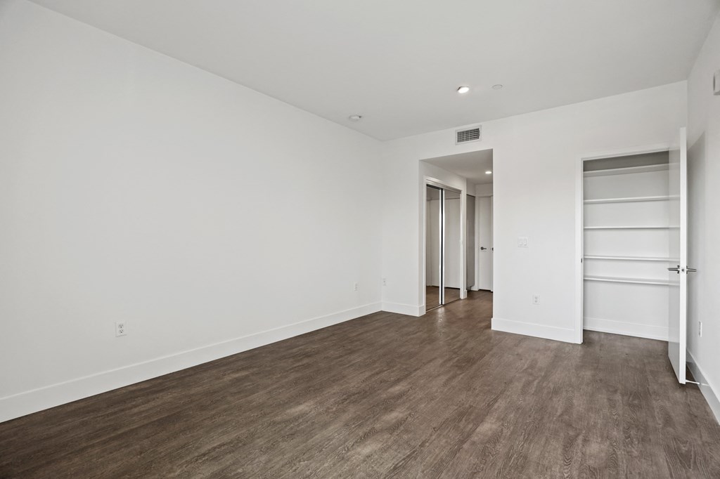 Bedroom with Two Mirrored Closets and a Closet with Shelving