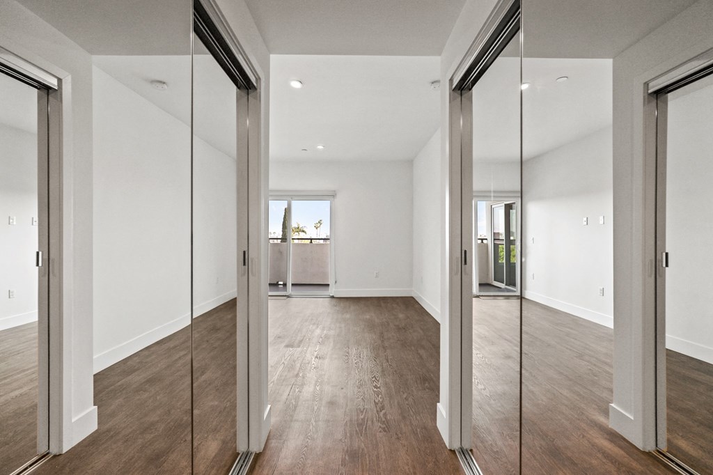 Bedroom with Two Mirrored Closets, Vinyl Flooring, and Patio